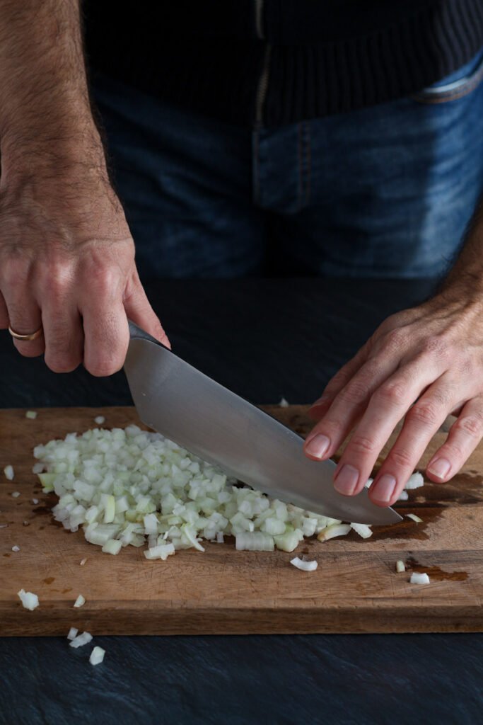 Hands chopping onion