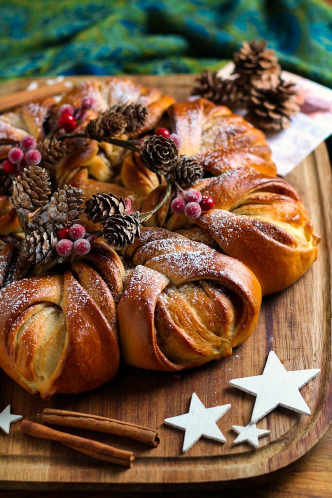 Cinnamon Star Bread on a wooden board with Christmas decorations.