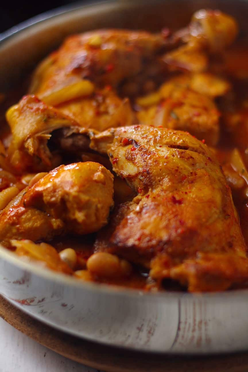 Chicken stew with beans in a rustic pot, close-up shot