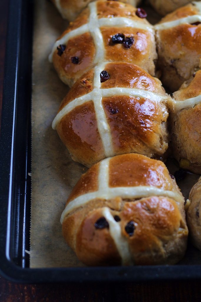 Fruity Hot Cross Buns baked and glazed on a tray.