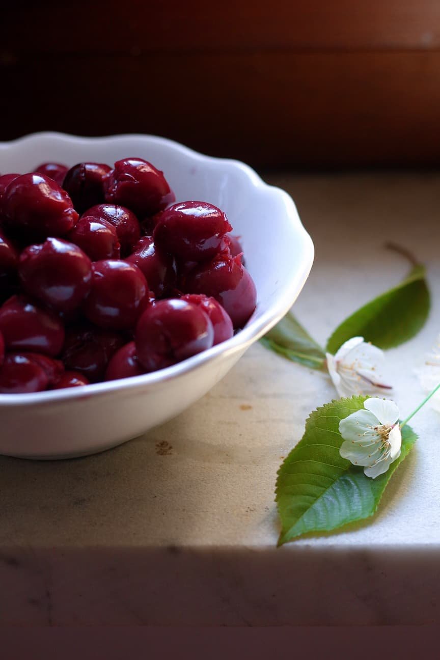 A bowl of cherries with a cherry blossom.