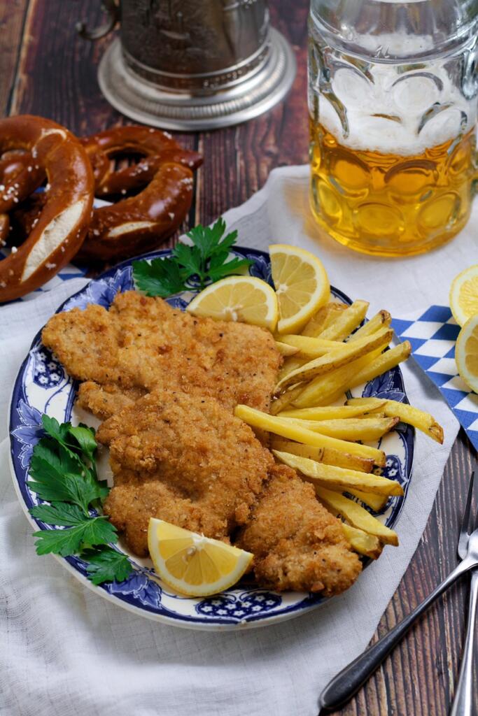 Bavarian Pork Schnitzel on a plate with beer and pretzels.