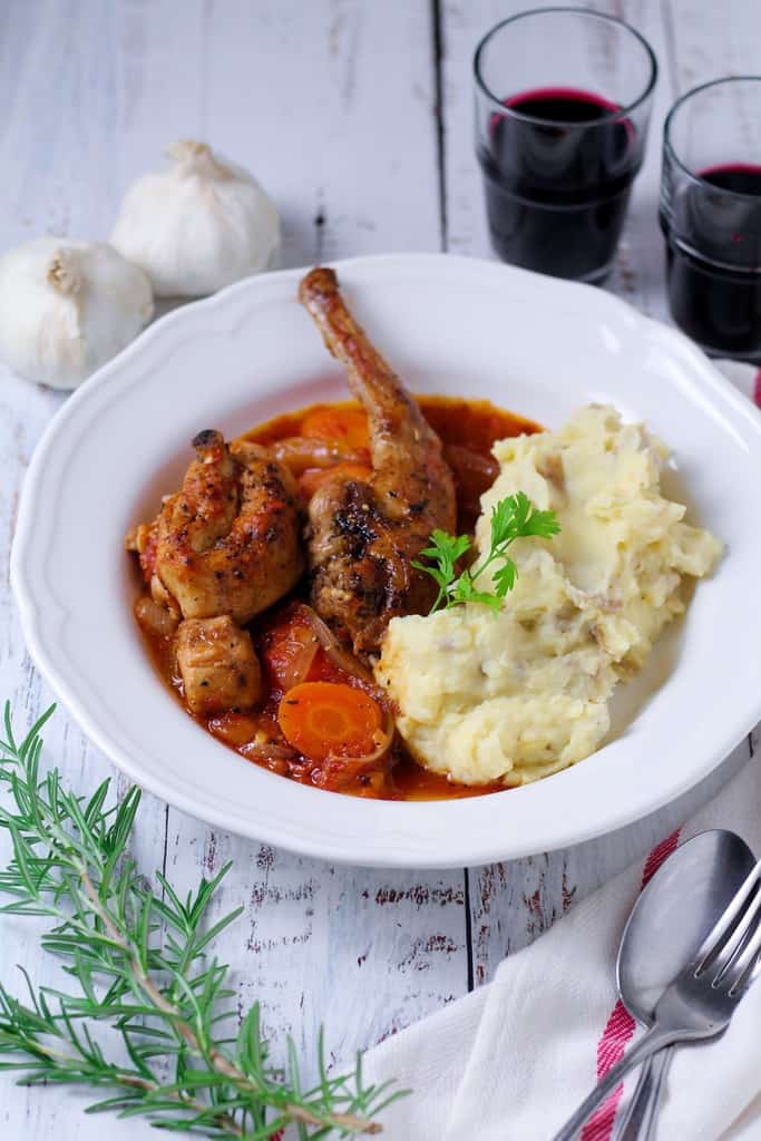 A picture of a Country-style Farmhouse Rabbit Stew served with mashed potatoes and red wine