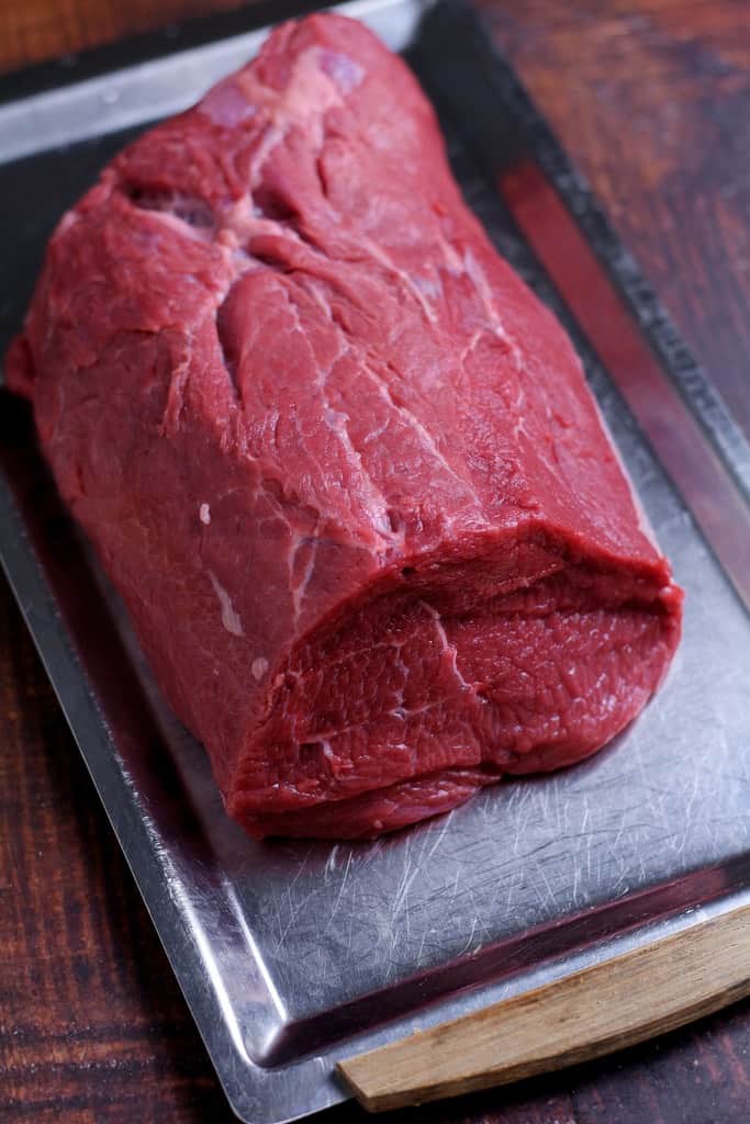 A piece of Rump tail or tri-tip beef on a tray.