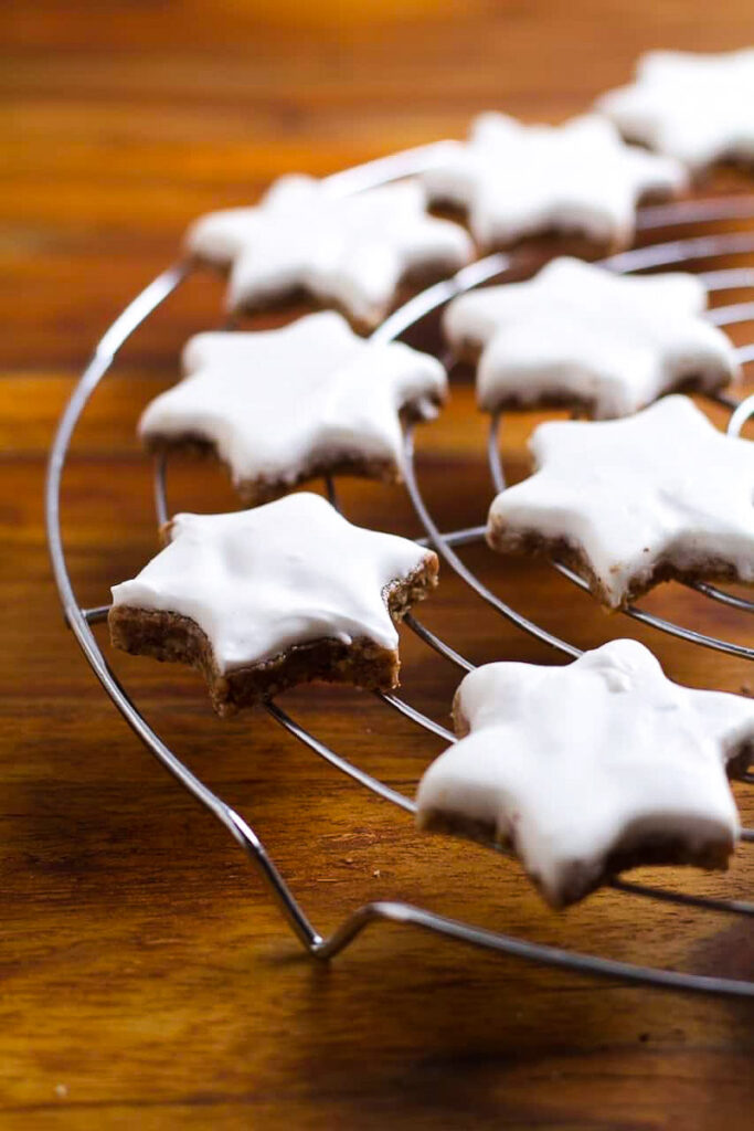 Frosted Zimtsterne on a wire rack.