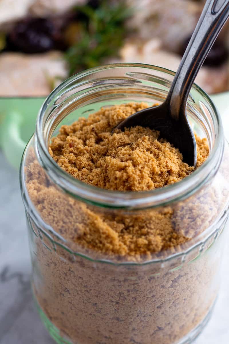 A jar of soft brown sugar with a spoon in it.