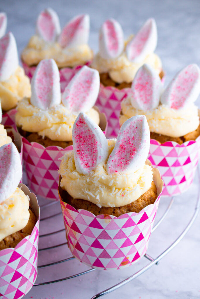 Fully decorated Easter Bunny Cupcakes on a cooling rack.