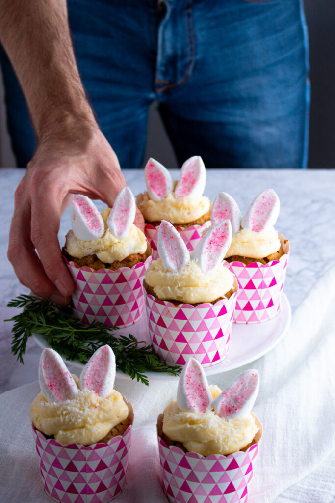 Cook Jay Wadams picking up Easter Bunny Cupcakes from a tray.