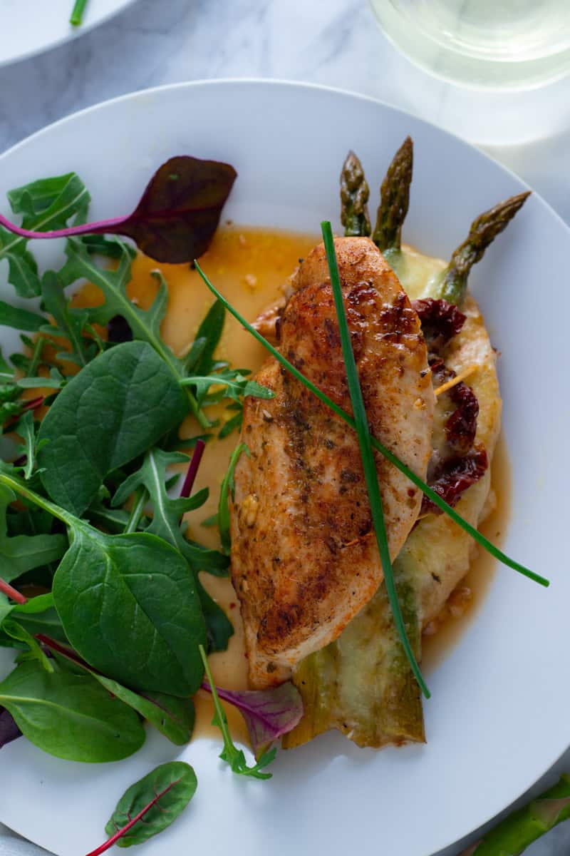 An easy-breezy dinner for springtime, Asparagus Stuffed Chicken Breasts are simple to prepare but look and taste fabulous. This is a brilliant recipe for an easy dinner party or Easter lunch.