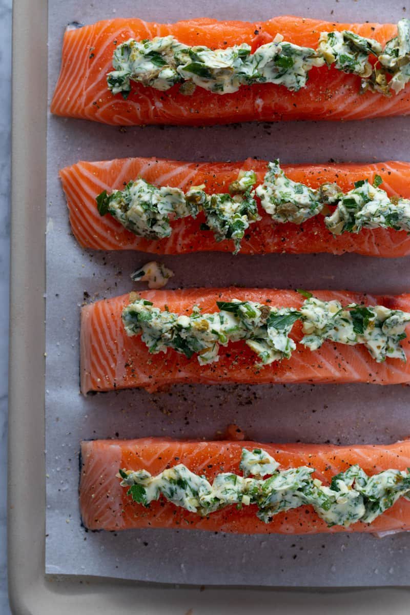 Salmon fillets on a baking tray for garlic and herb roast salmon.
