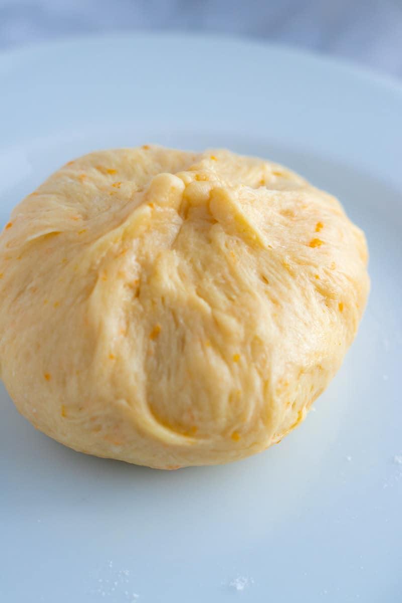 An unbaked dumpling seen from underneath showing the seal