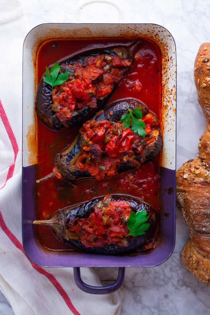 Imam Bayildi Turkish Stuffed Eggplants in a roasting dish with fresh bread