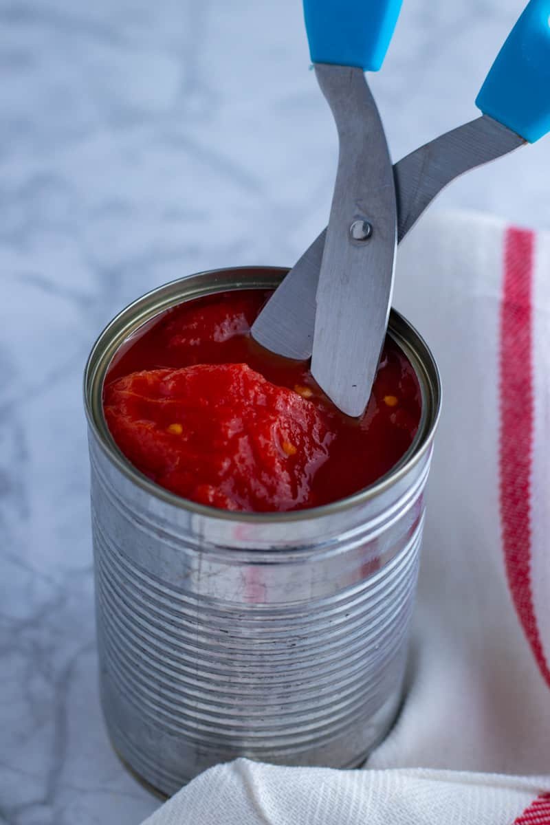 Tomatoes with scissors in a can