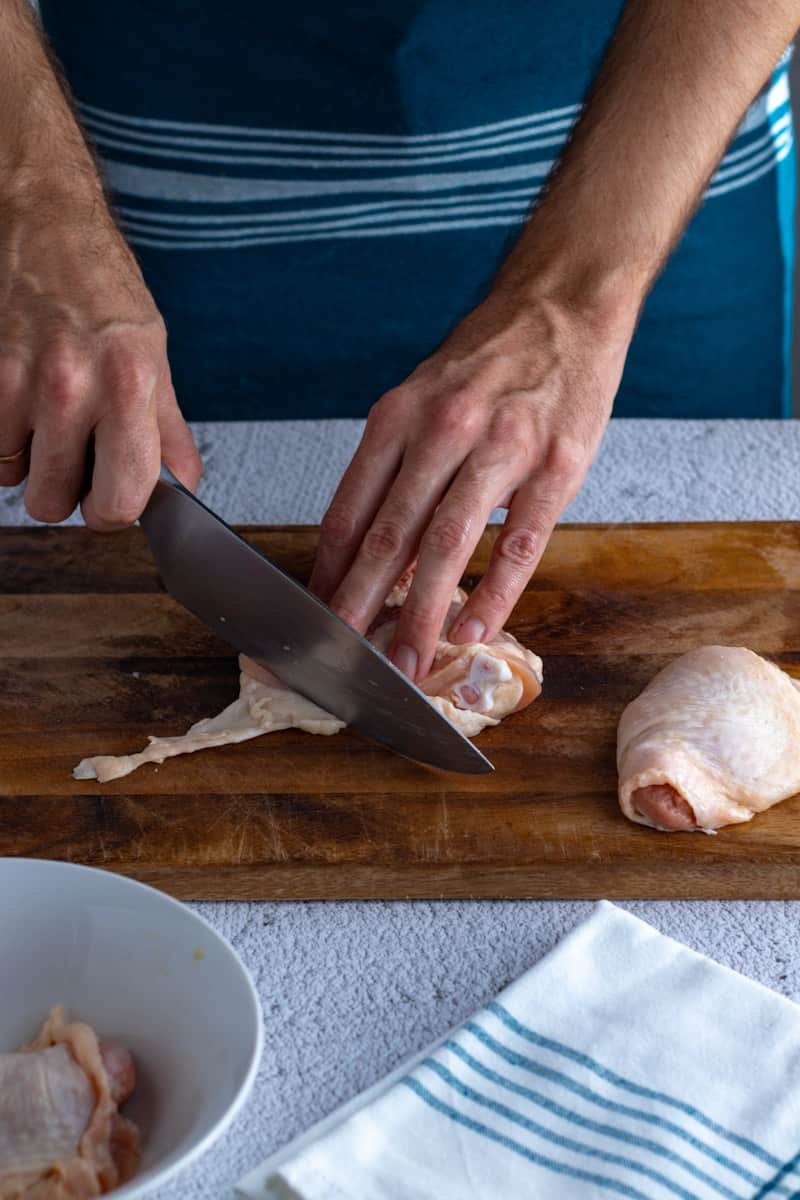 Removing excess skin from chicken thigh