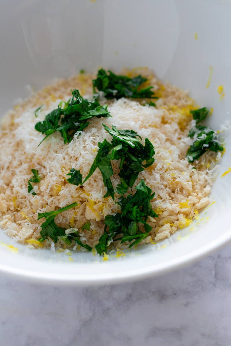 Parmesan, parsley, lemon zest and bread crumbs in a bowl.