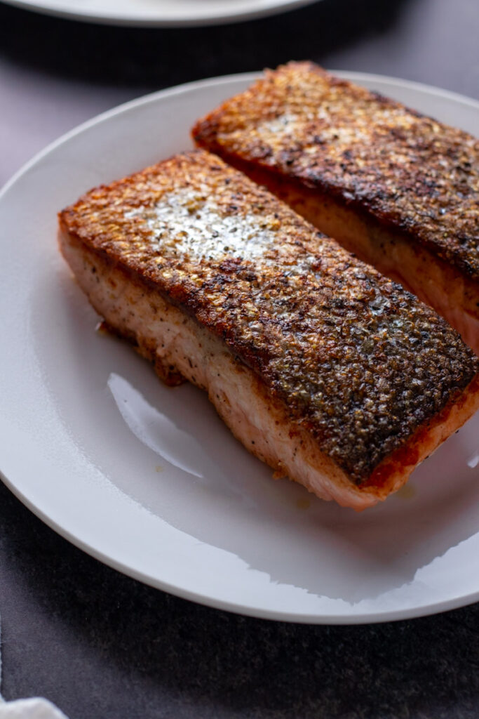 Crispy skinned salmon on a plate.