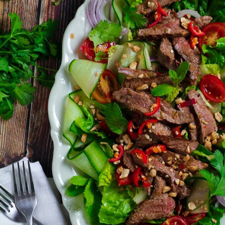 Easy Thai Beef Salad on a serving platter with beef steak, fresh herbs and vegetables.