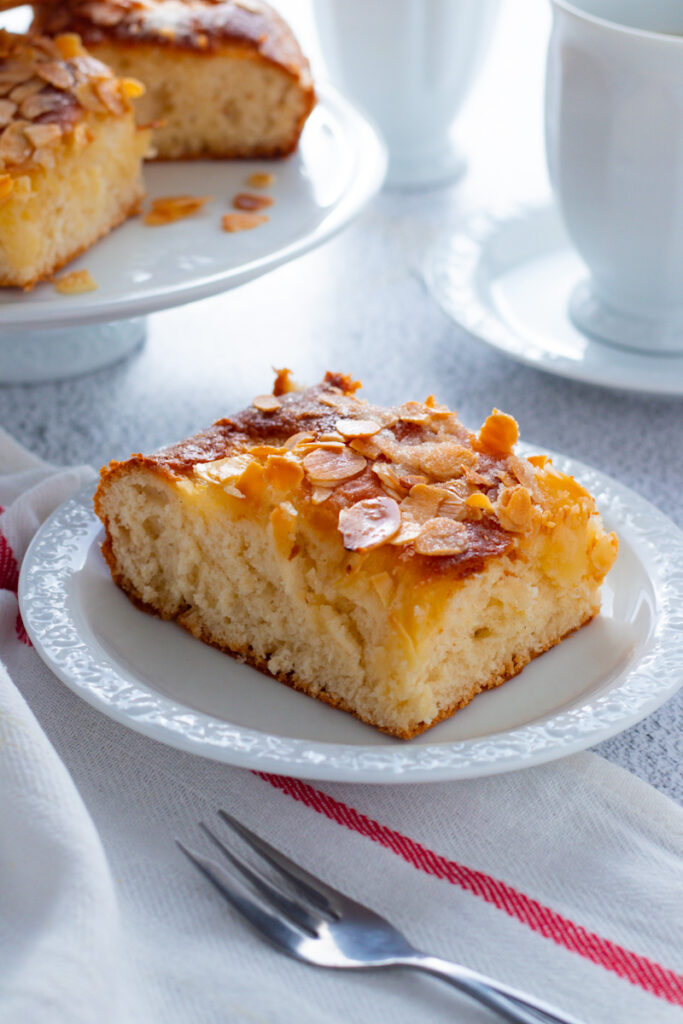 A slice of butterkuchen with a coffee and a fork.