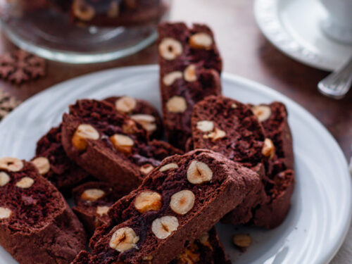 Rich chocolate hazelnut biscotti with chunks of hazelnuts on a cooling rack