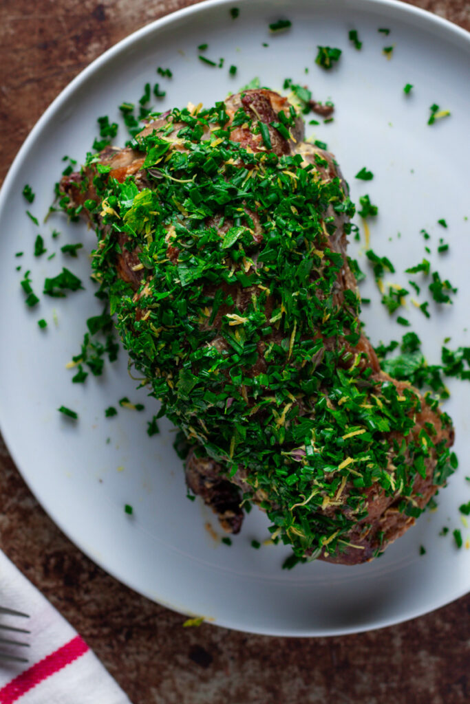 Lamb Leg with fresh herb crust on a plate, after roasting.