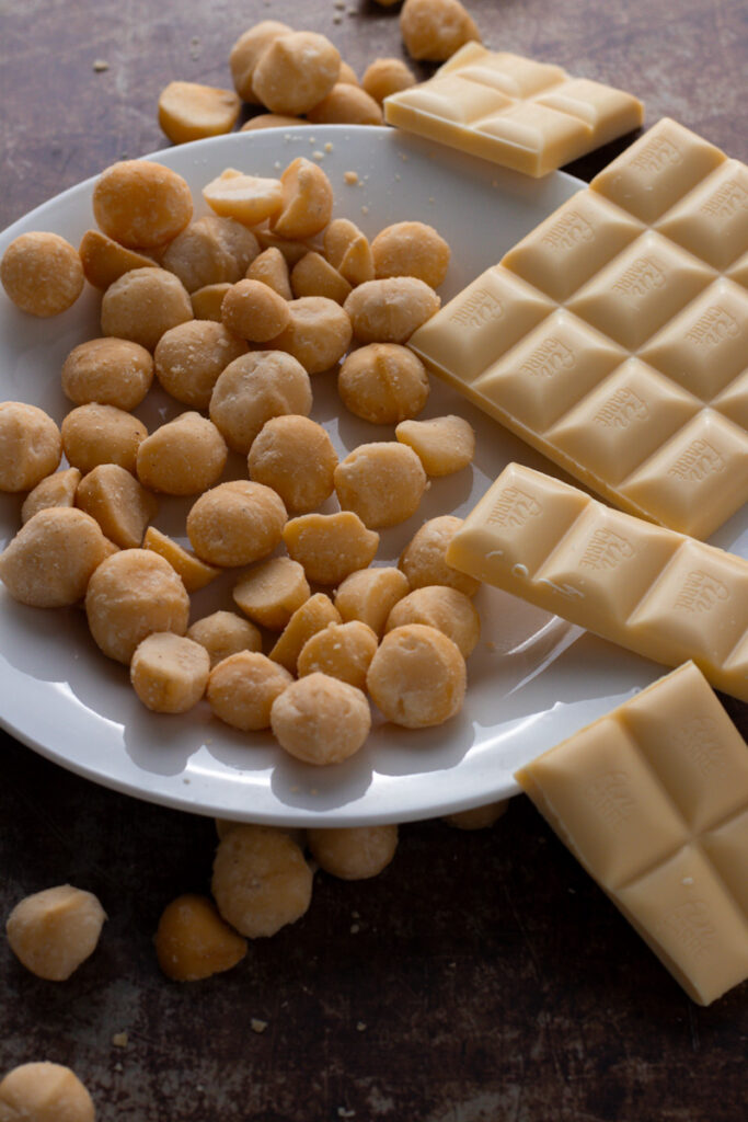 Macadamias and white chocolate on a plate.