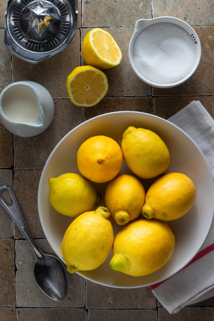 Lemons, sugar and cream seen from above on a table.