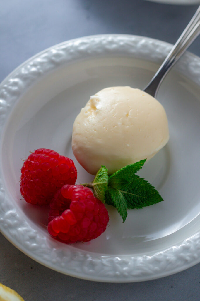 A scoop of lemon posset on a plate.