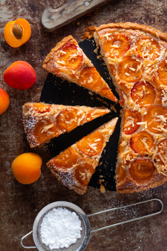 Apricot tart seen from aboce with some slices.