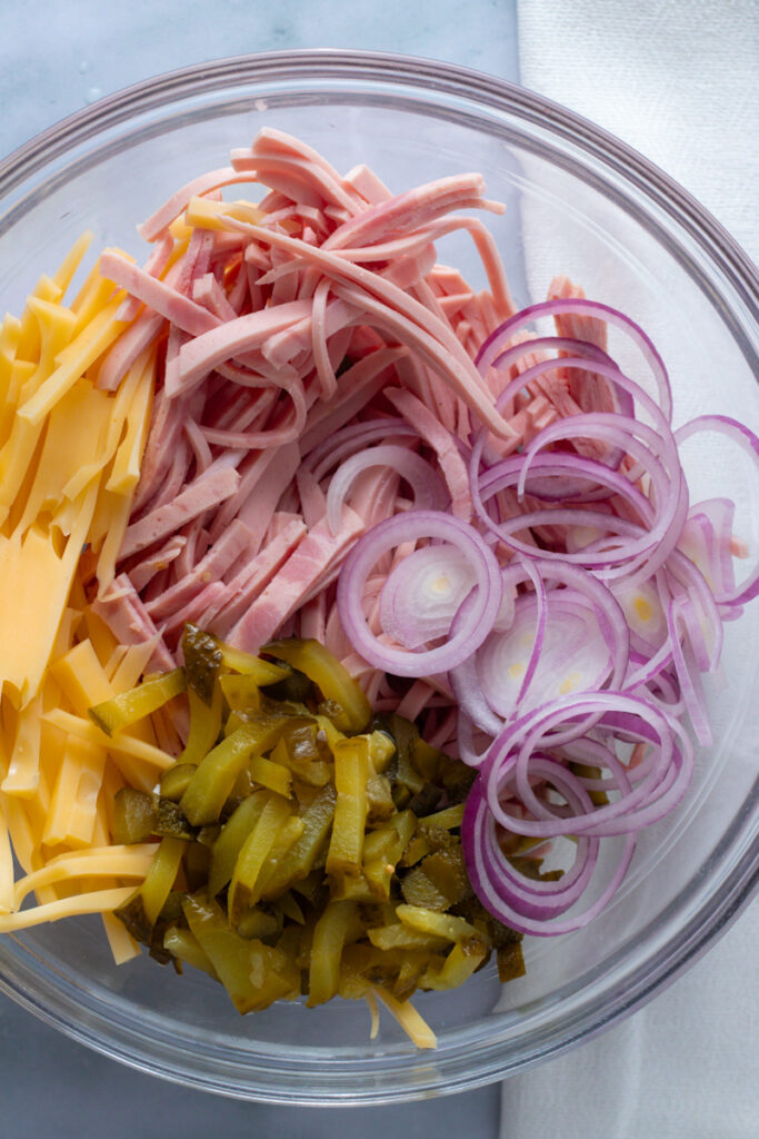 Ingredients for Swiss or German Sausage salad in a bowl.