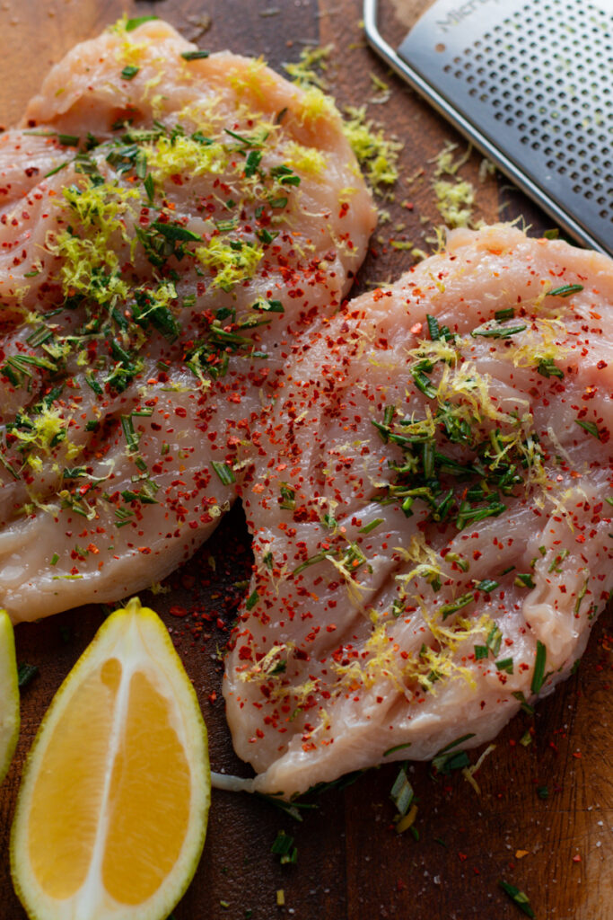 Marinating chicken breasts with herbs and lemon zest.