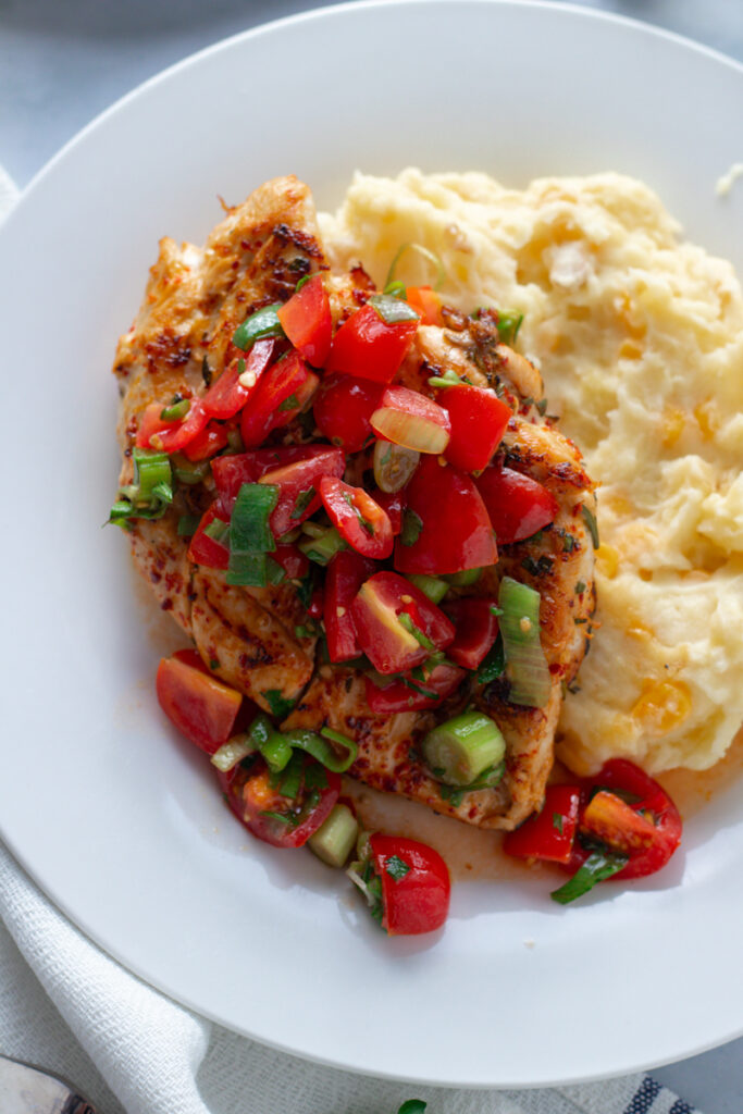 Herby Tomato Salsa Chicken Breasts on plates with potato and sweetcorn mash.