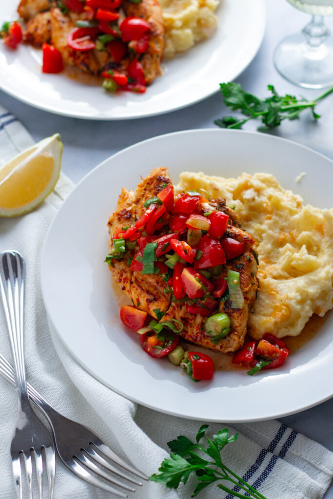 Herby Tomato Salsa Chicken Breasts on plates with potato and sweetcorn mash.