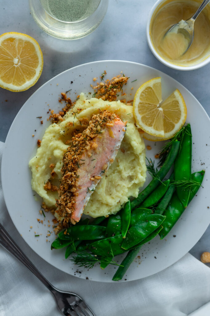 Hazelnut Crusted Salmon on a plate with mashed potatoes, beans and snowpeas.