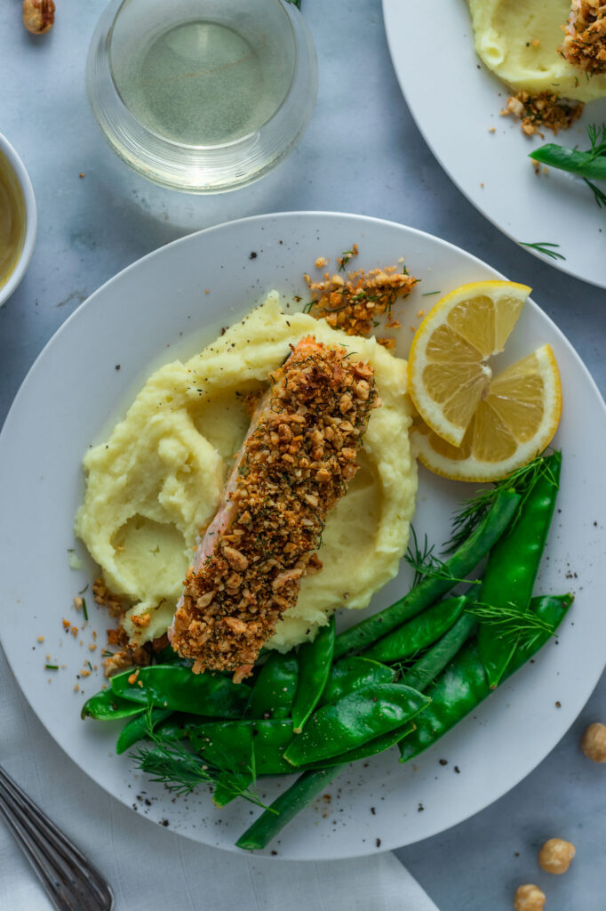 Hazelnut Crusted Salmon on a plate with mashed potatoes, beans and snowpeas.