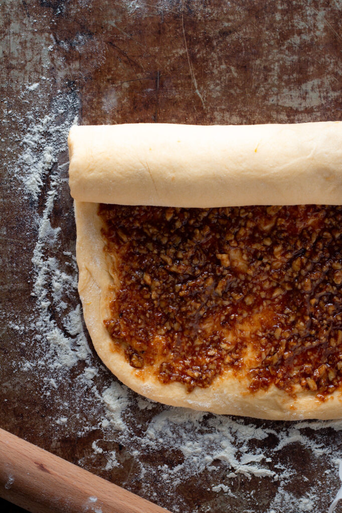 Nut filling spread on dough for Nusszopf, rolling the dough.