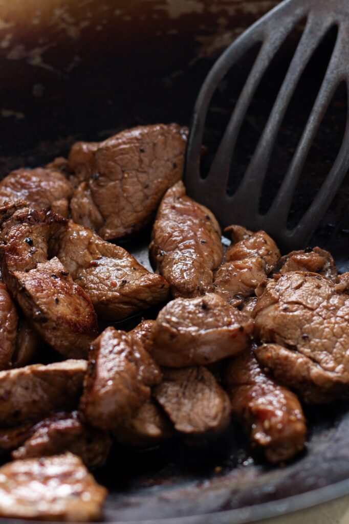 Well browned pork tenderloin in a wok.