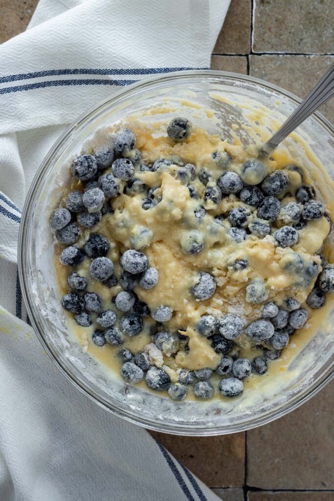 Blueberries being mixed into muffin batter.