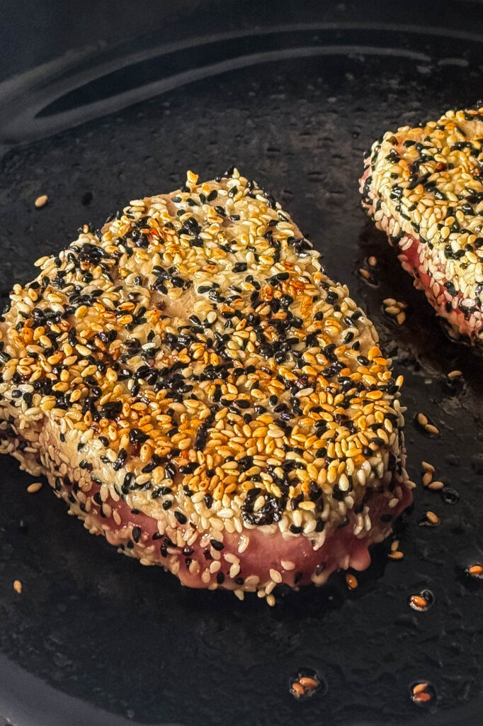 Sesame crusted tuna in a cast iron skillet.