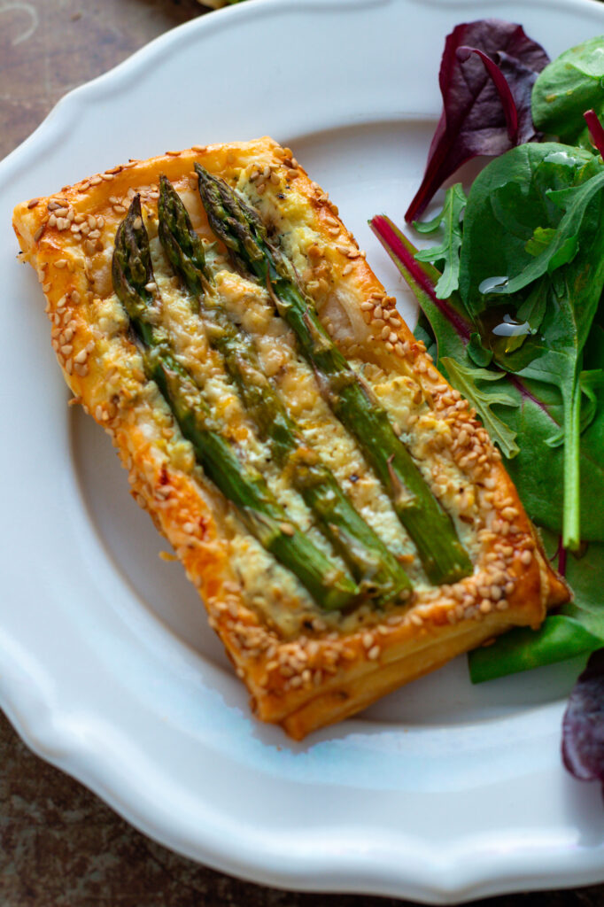 Asparagus and Goat Cheese Tart on a plate with salad.