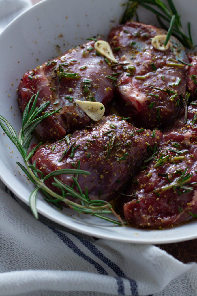 Lamb marinating with garlic and herbs.