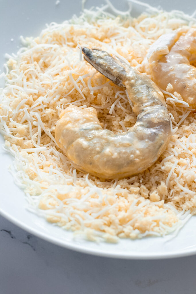 Prawn being crumbed in coconut and panko.