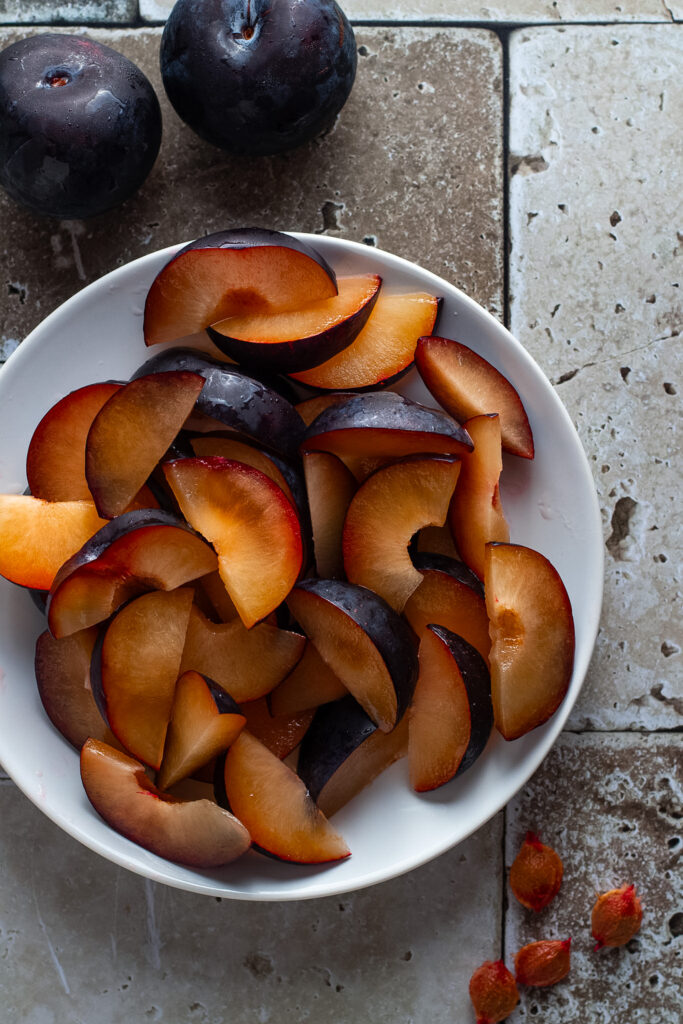 Sliced plums in a bowl.
