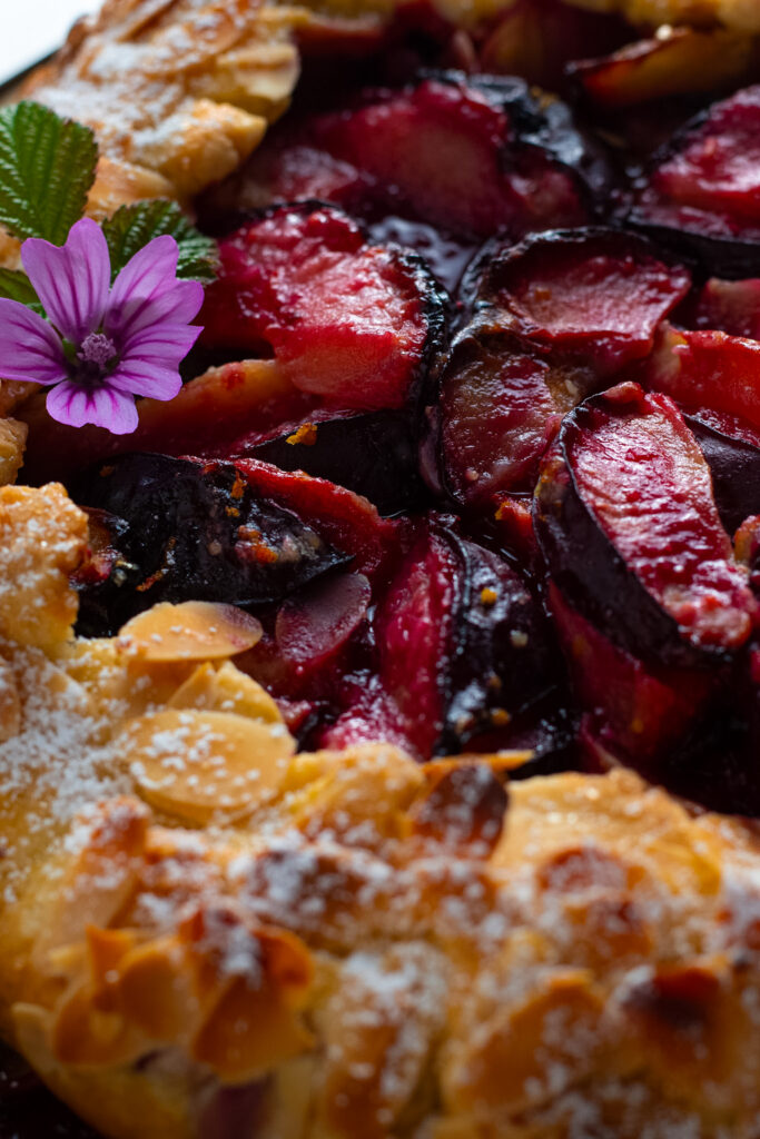 Plum galette close up showing bubbling plums.