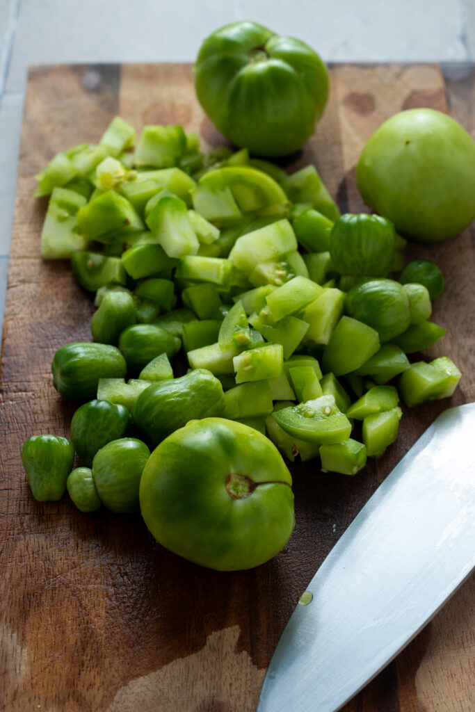 Chopped green tomatoes on a board.