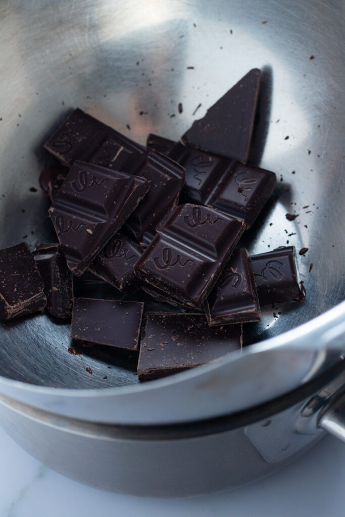 Dark chocolate squares in a metal bowl, preparing for German Marble Cake.