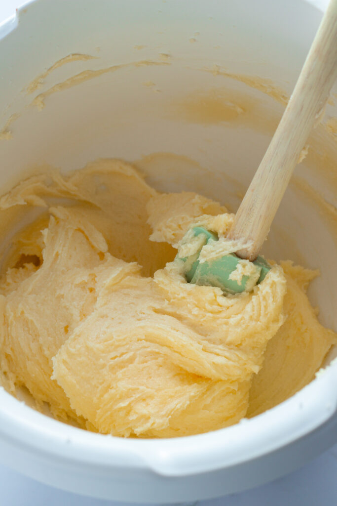 Cake batter in a white bowl with a spatula, preparing for Marmorkuchen (German Marble Cake).