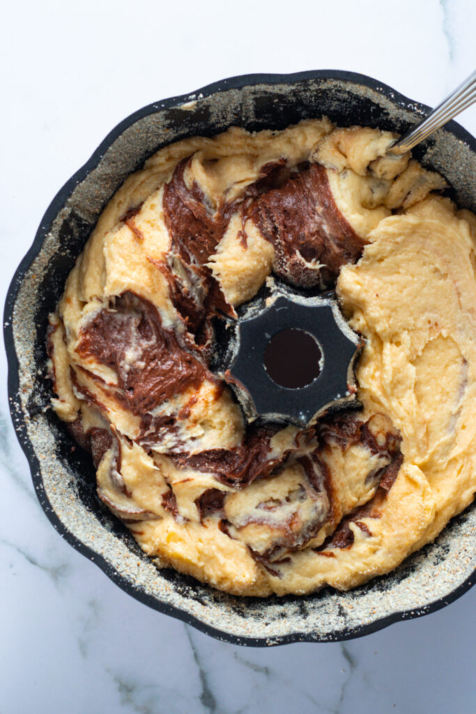 Unbaked Marmorkuchen (German Marble Cake) batter in a Bundt pan, ready for the oven.